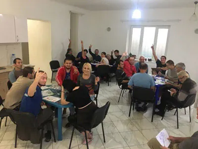 Учасники групового заняття піднімають руки