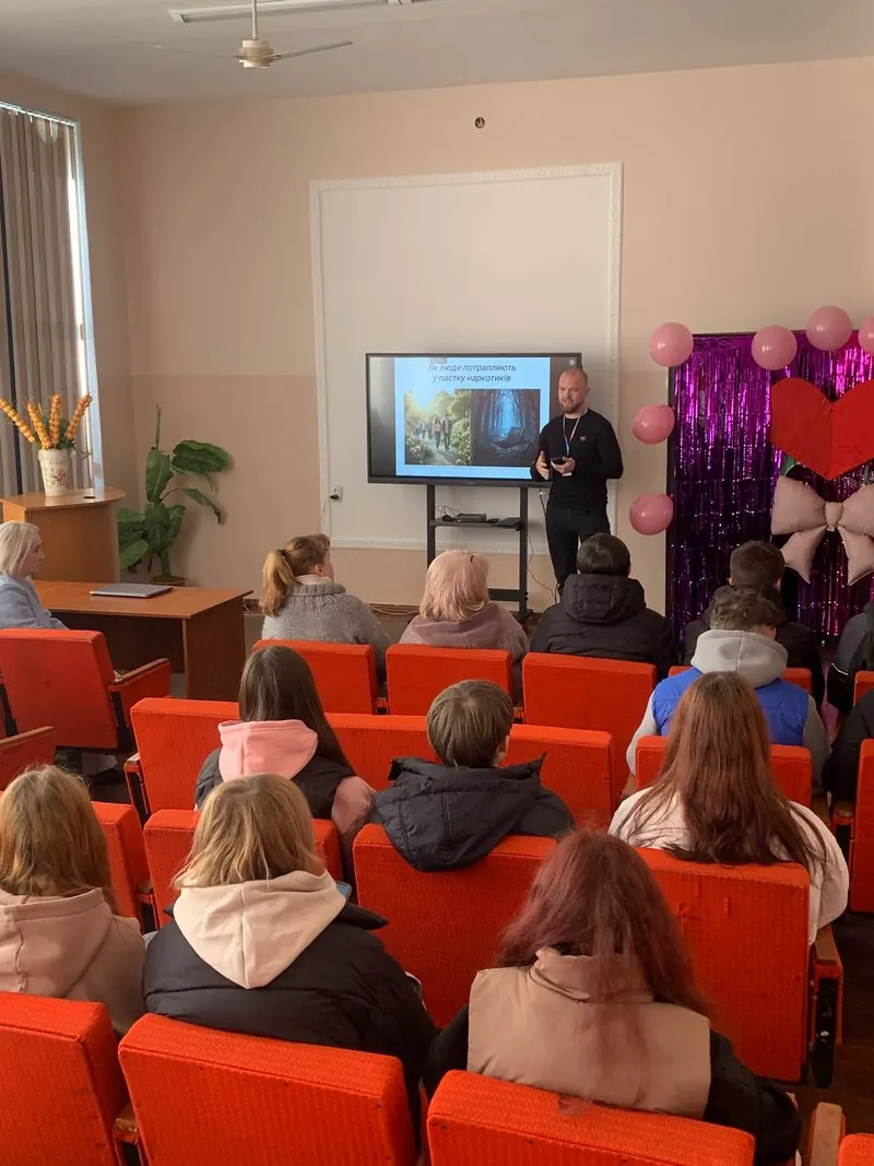 Лекція для пацієнтів і родин у залі з червоними кріслами